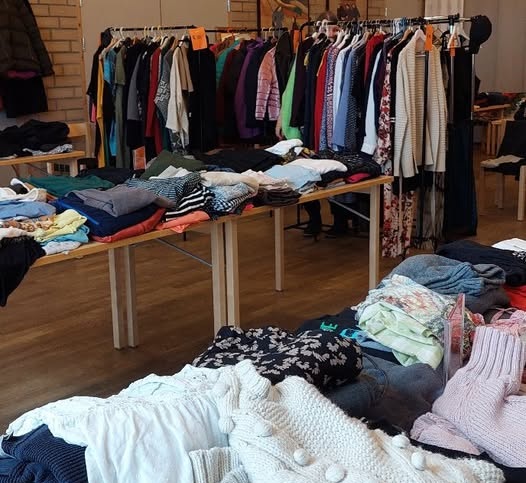 Bilde av klær på bord og på stativ